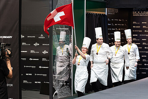 Le Team Switzerland au Bocuse d’Or Europe 2022: Céline Maier, commis, 20 ans, Christoph Hunziker, 40 ans, Propriétaire du Restaurant Schüpbärg-Beizli à Schüpfen, Dominic Bucher, coach, 50 ans, Directeur du Seniorenzentrum à Schüpfen, Mario Garcia, président et membre du jury, 30 ans, Sous-chef exécutif à l’Hôpital Cantonal Lucerne.