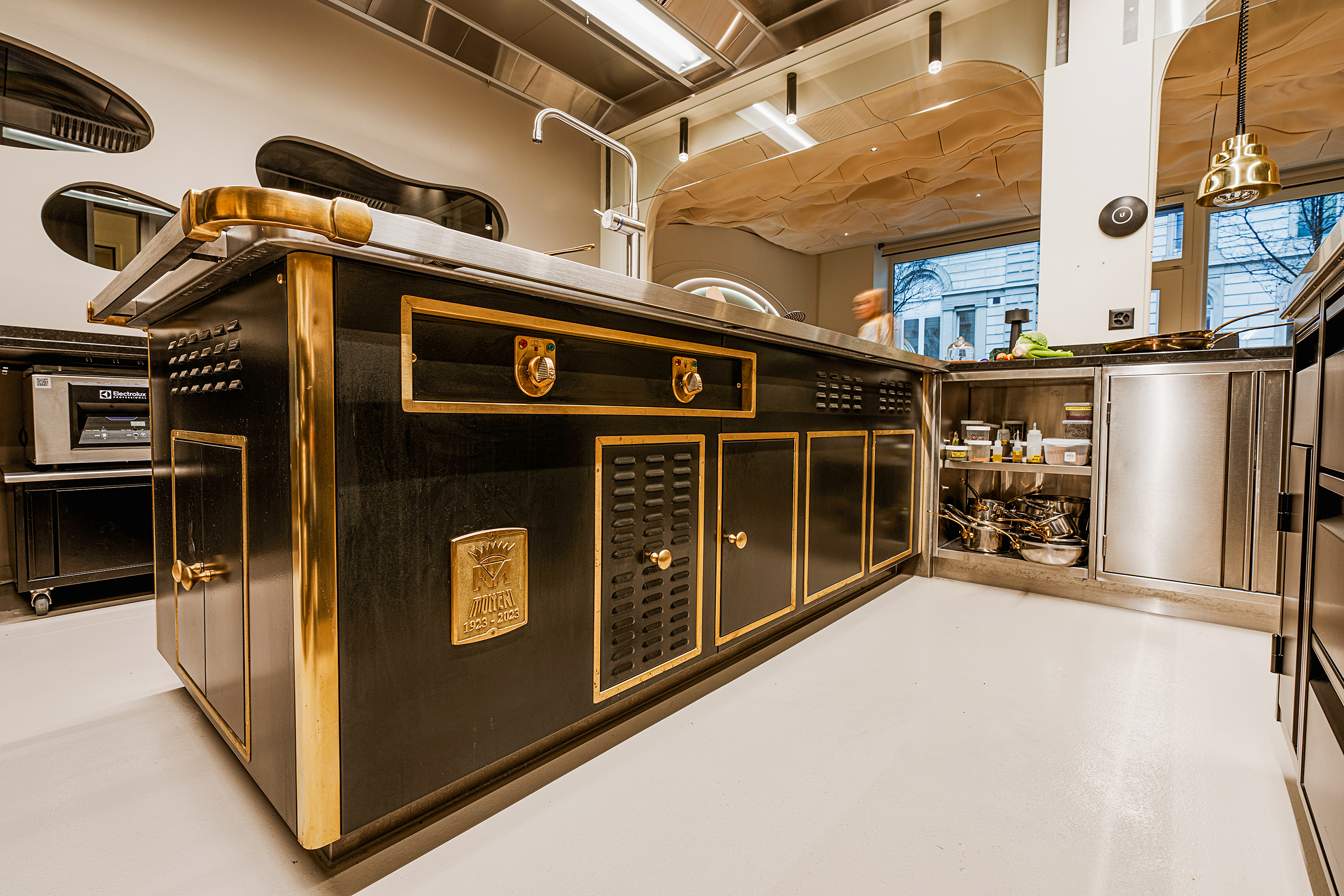 Hinter den goldumrahmten Flügeltüren bieten Tablare zusätzliche Ablageflächen.