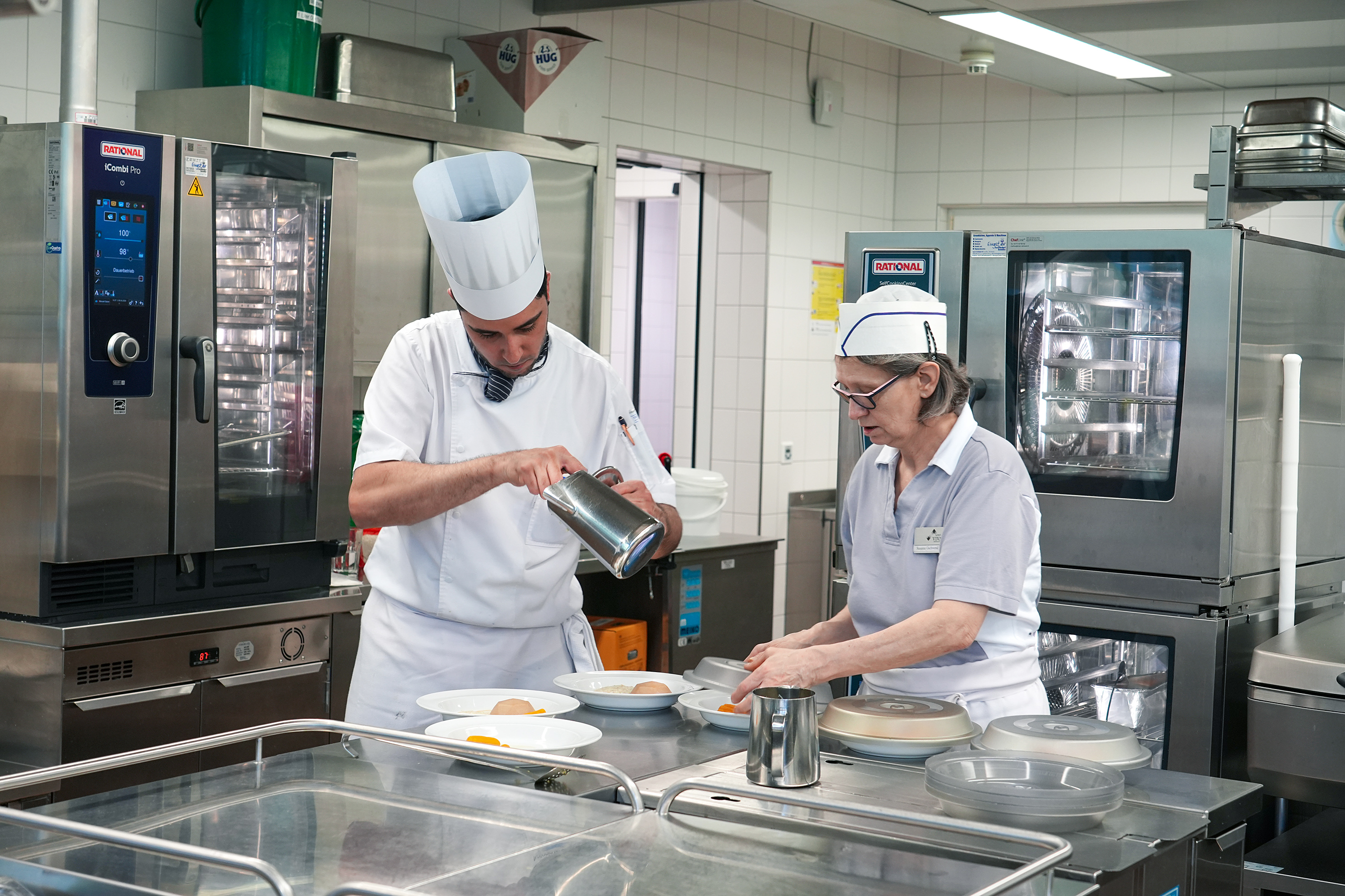 Für die Bewohnenden, die nicht im Speisesaal essen können, wird das Essen direkt in der Küche auf dem Teller angerichtet.