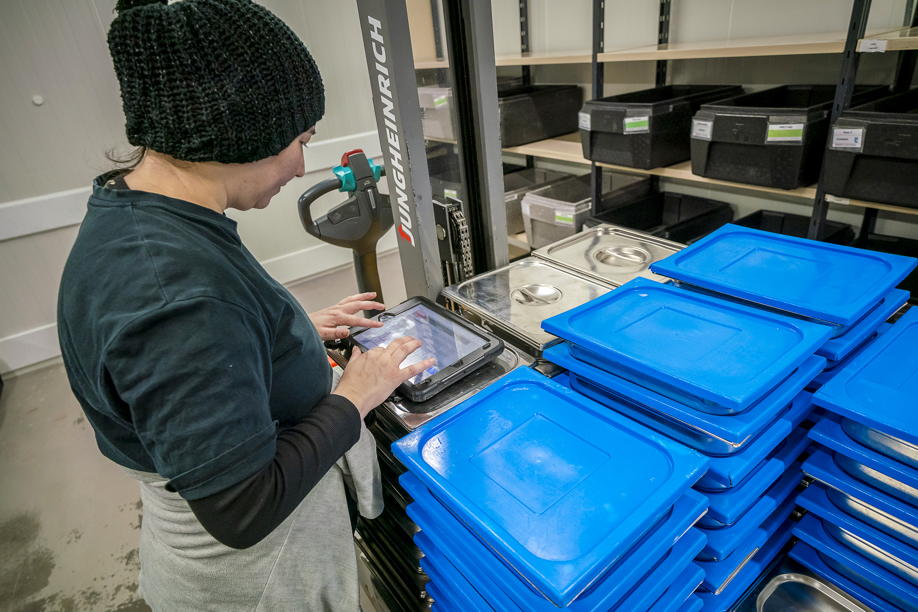 Fast alles digitalisiert: Genau nach Bestellsystem werden die Menukomponenten am Nachmittag vor der Auslieferung in die Transportbehälter verteilt.