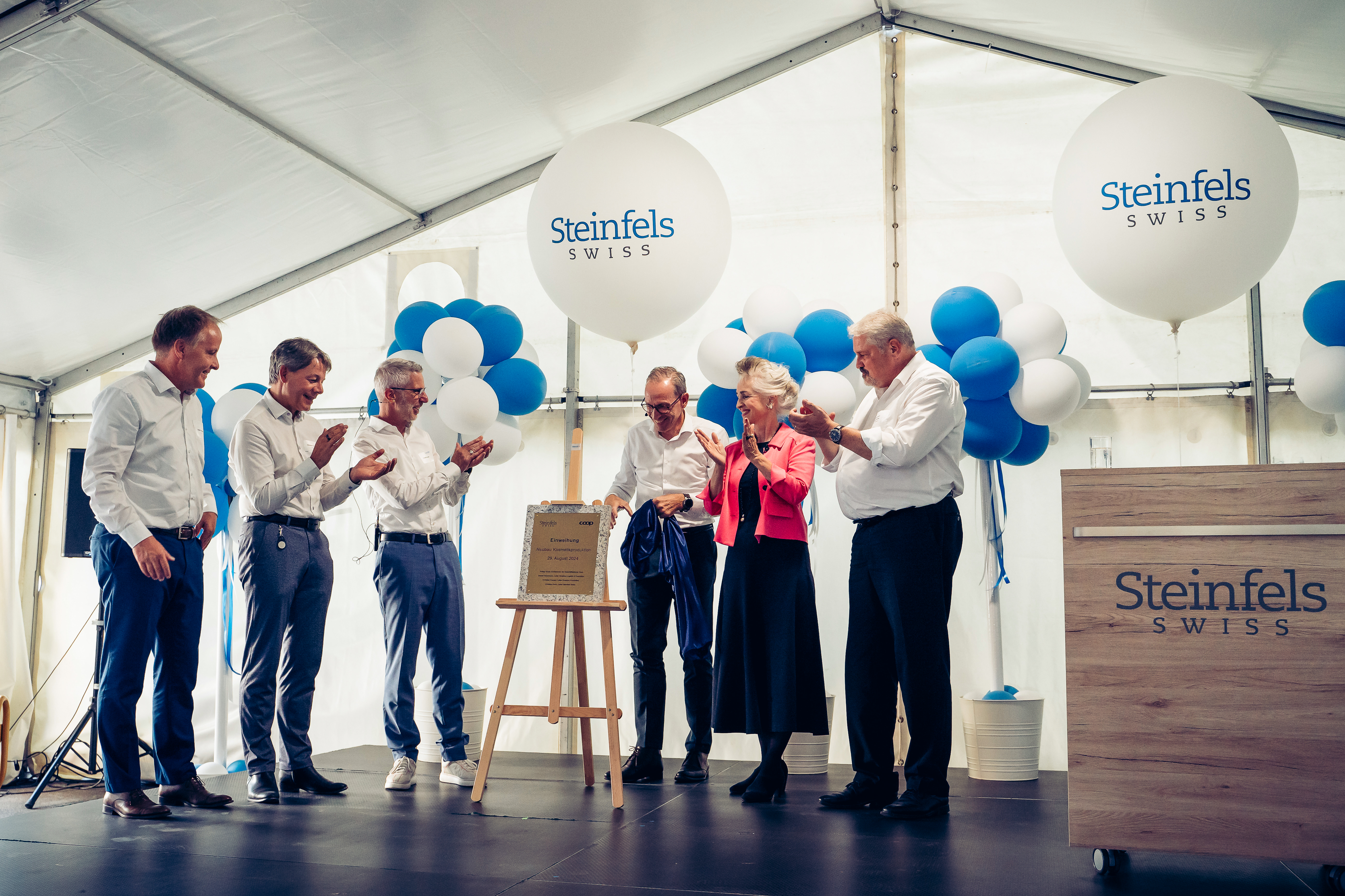 Philipp Wyss, CEO Coop (3.v.r.), enthüllt den Einweihungsstein und übergibt damit den Neubau symbolisch an Christian Koch, CEO Steinfels Swiss (3.v.l.).