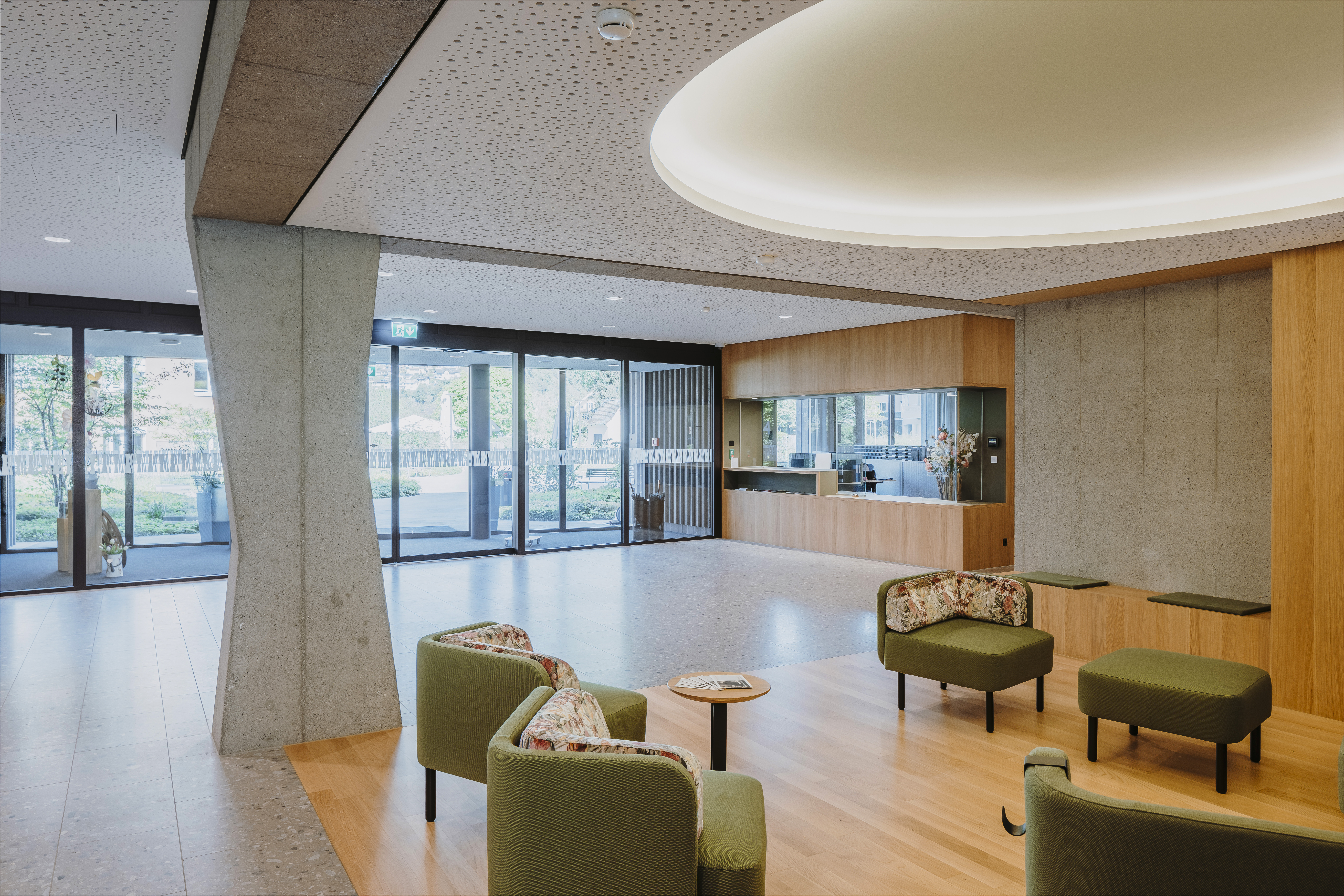 Der Eingangsbereich des Neubaus «Schmetterling» vereint Holz mit Sichtbeton.