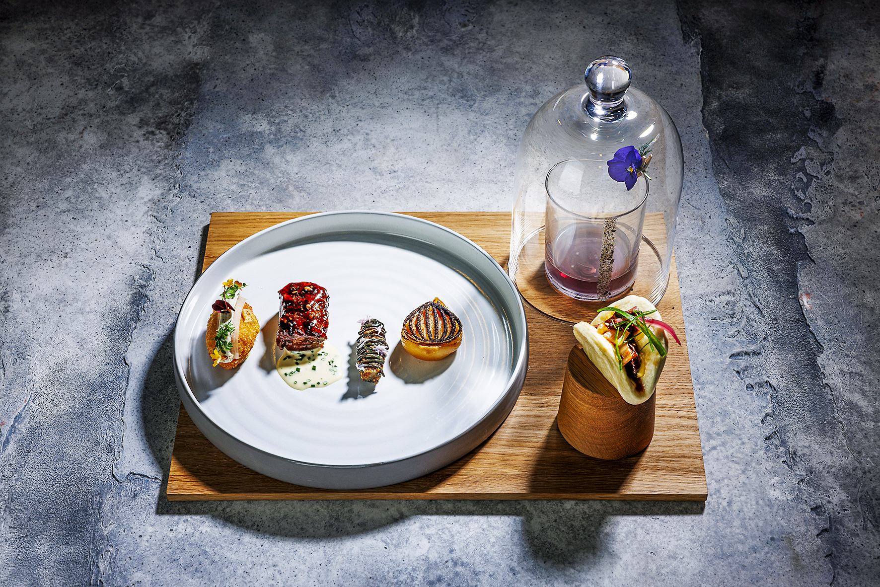 Hauptspeise von Céline Grossmann: Teriyaki Flat Iron vom japanischen Grill mit Yuzu-Sauce, Bao Bun mit sautiertem Nierenzapfen, dazu  gedämpfte Schwarzwurzel, Miso-Zwiebel, Belper-Knolle-Krokette und Mezcal-Cocktail.