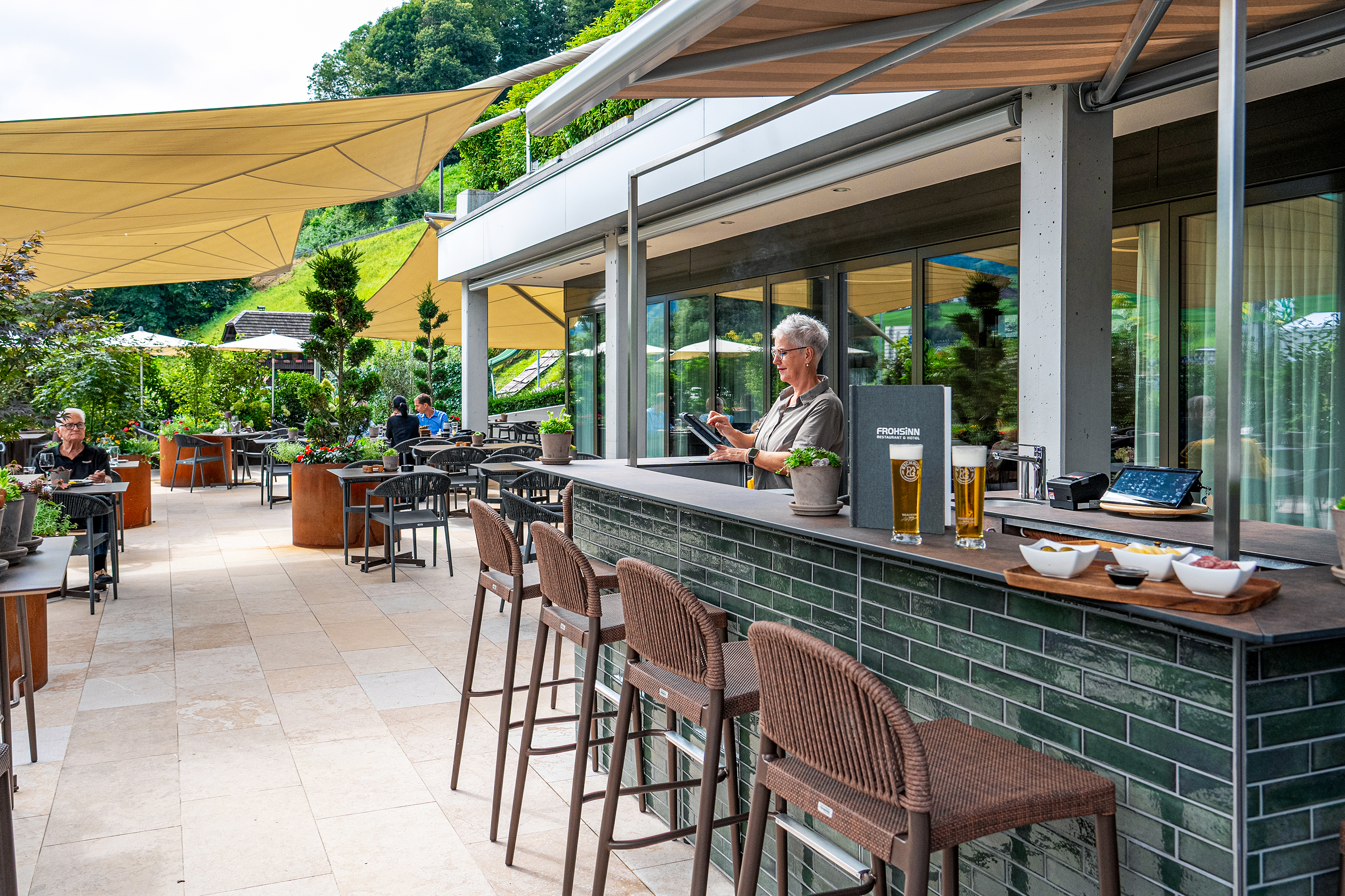 Chic und funktional: Die grün gekachelte Bar dient zugleich als Servicestation.