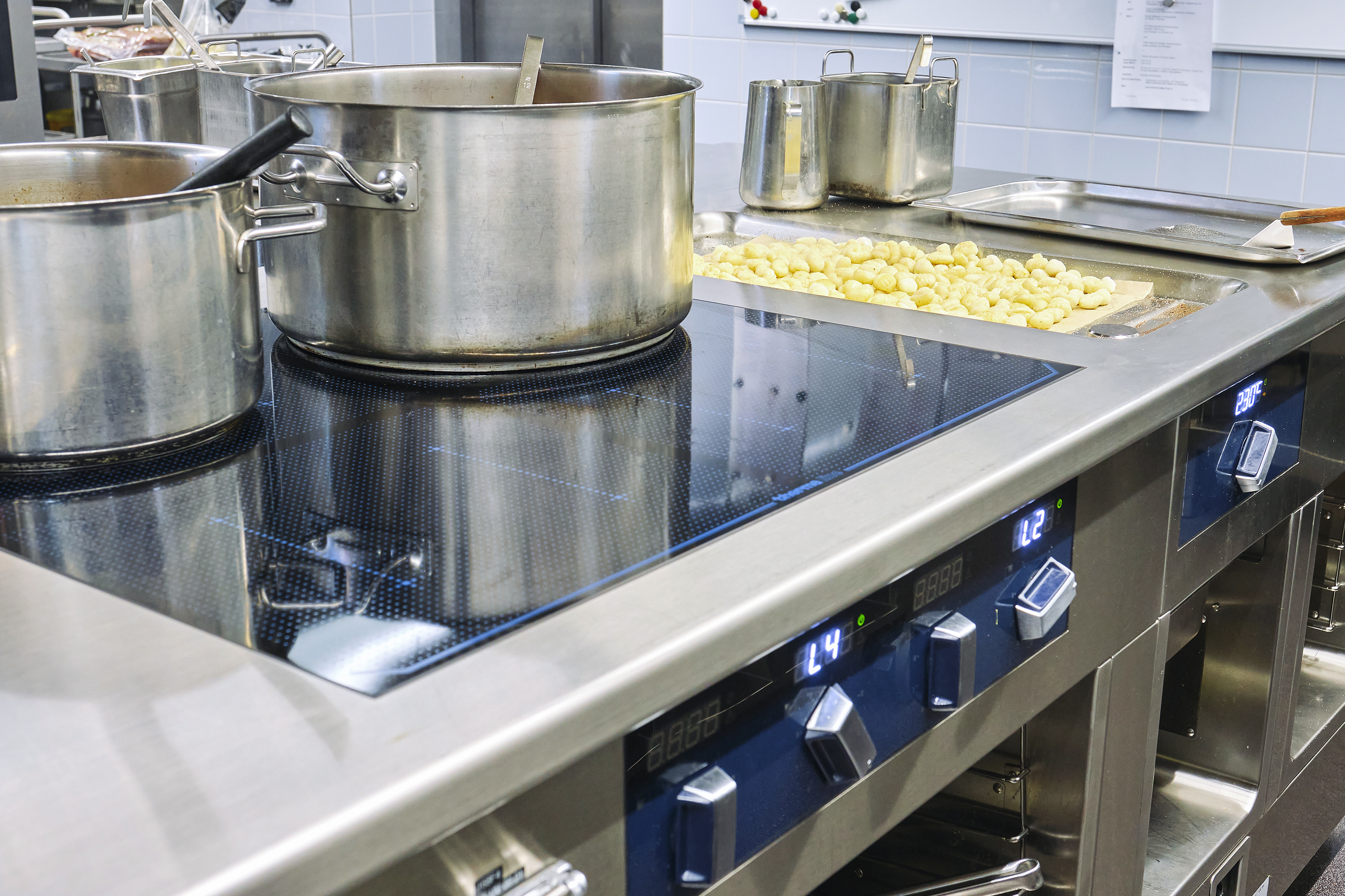 Der massgefertigte Thermaline-Herd aus Sursee mit Vollflächeninduktionskochfeld, Vier-Punkte-Induktionskochfeld, Multifunktionsbräter, der auch als Bain-Marie genutzt werden kann, sowie Griddleplatte und Fritteuse.