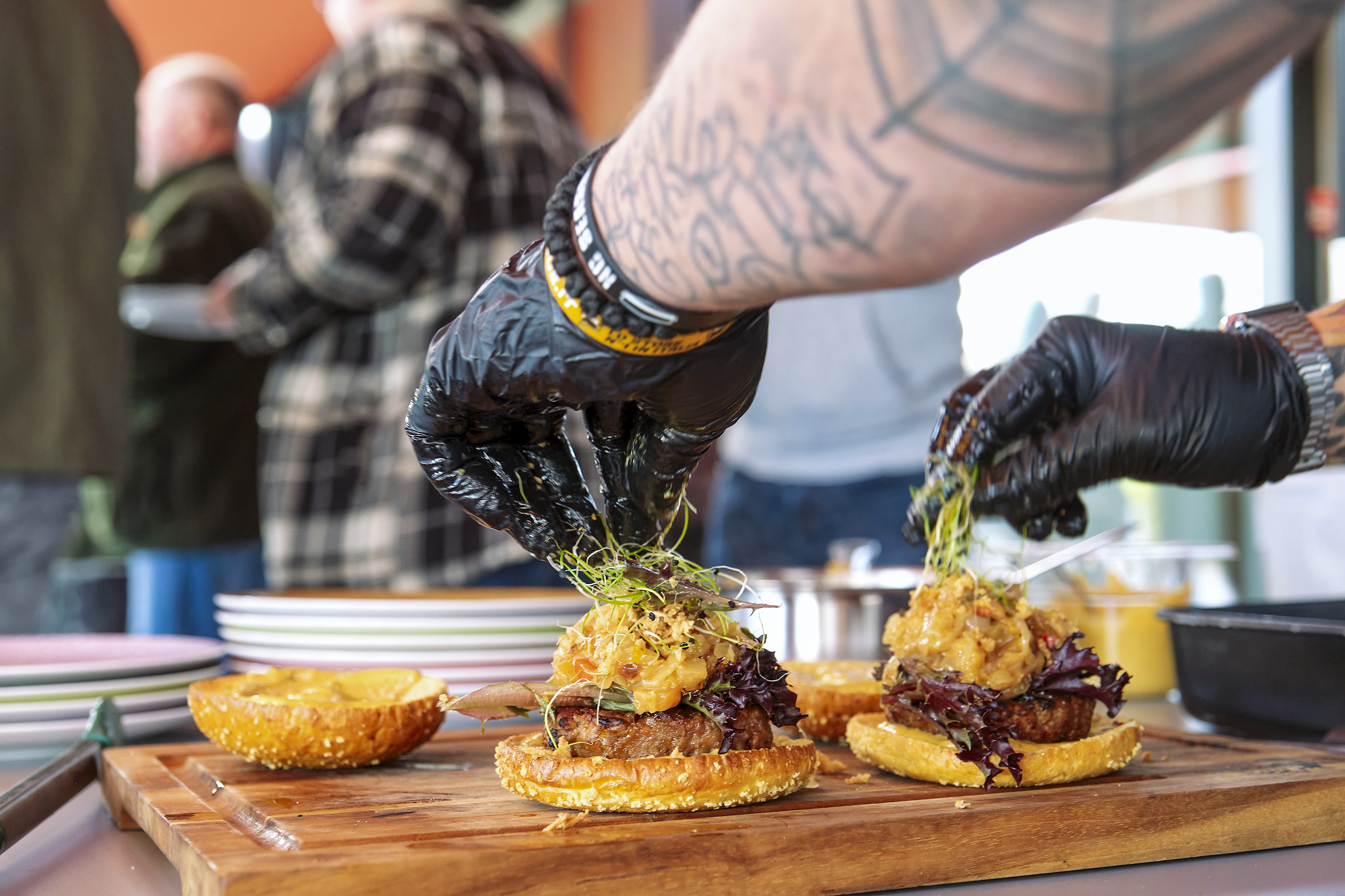 Die Pattys kommen in ein knuspriges Maisbrötchen mit Salat, Mango-Chutney und Senfsauce.
