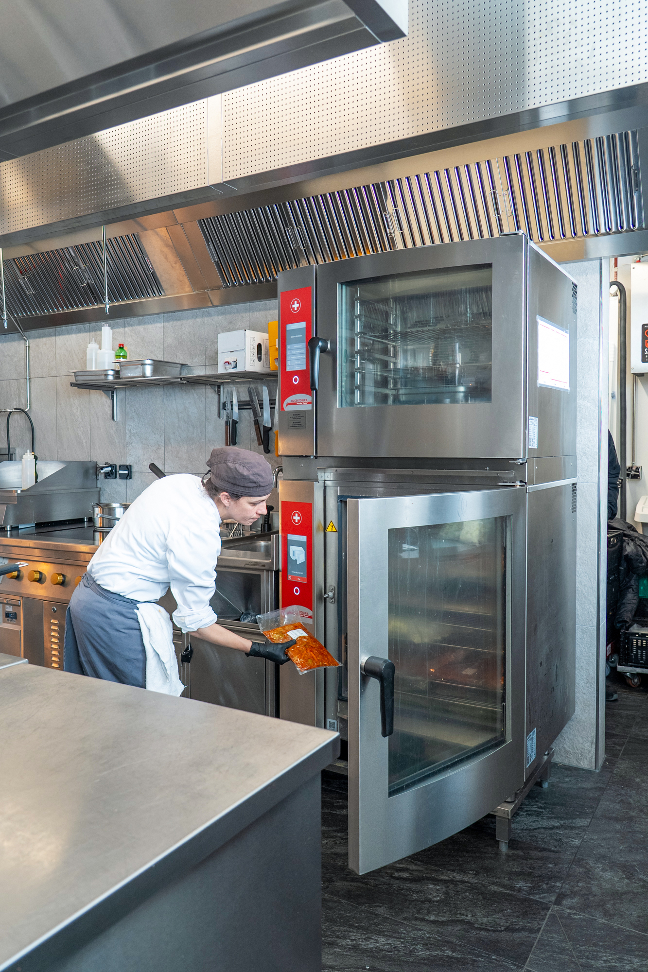 Mitarbeitende regenerieren in zwei grossen Kombisteamern der Hugentobler Schweizer Kochsysteme AG vakuumierte Speisen.