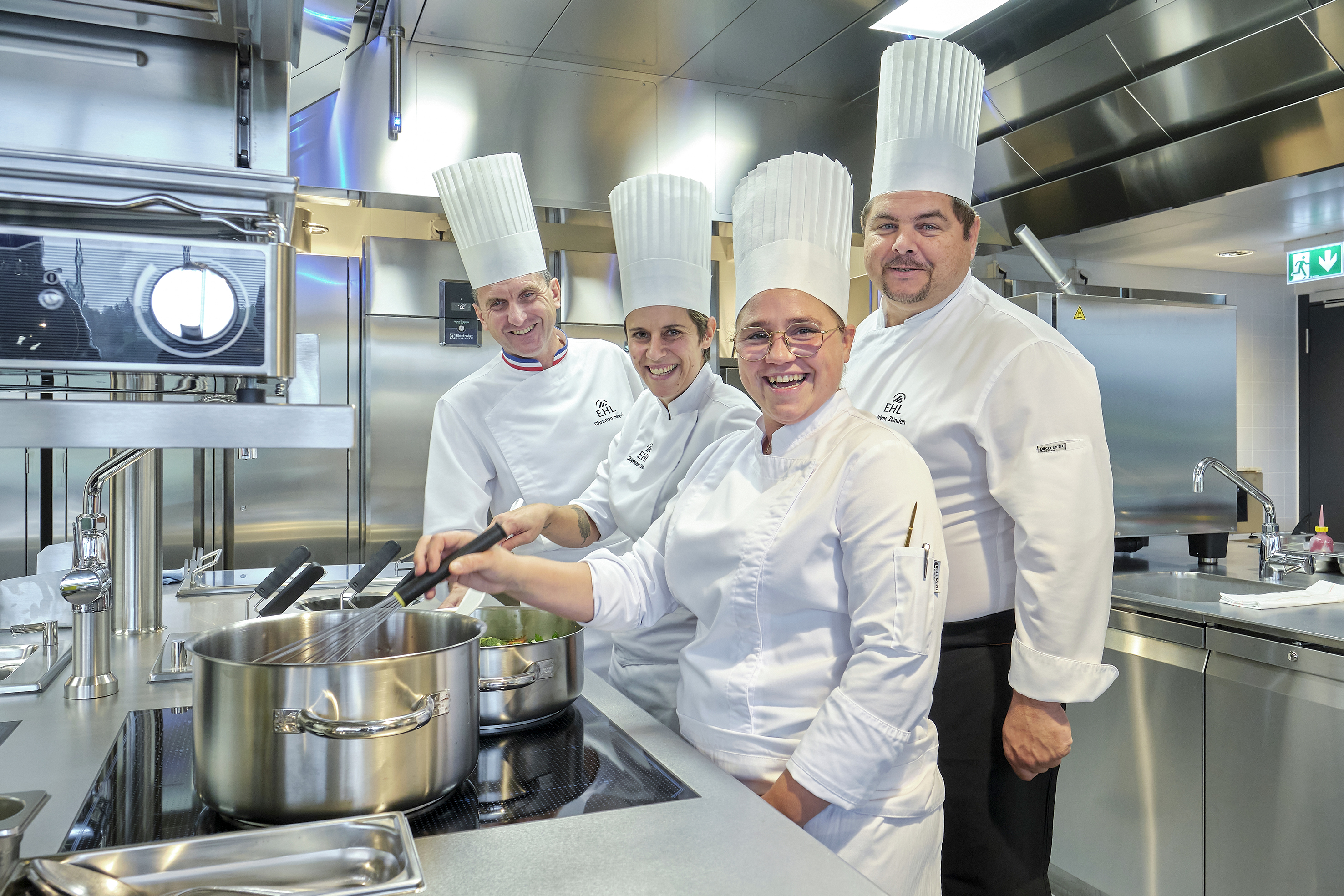 Die beiden Chef de Partie des Shadwood sind begeistert von der neuen Küche: Tessa Jousson (vorne) und Stéphanie Ferreira. Hier mit Christian Segui, Executive Chef an der EHL (l.) und Jérome Zbinden, Kitchen Outlets Manager an der EHL.