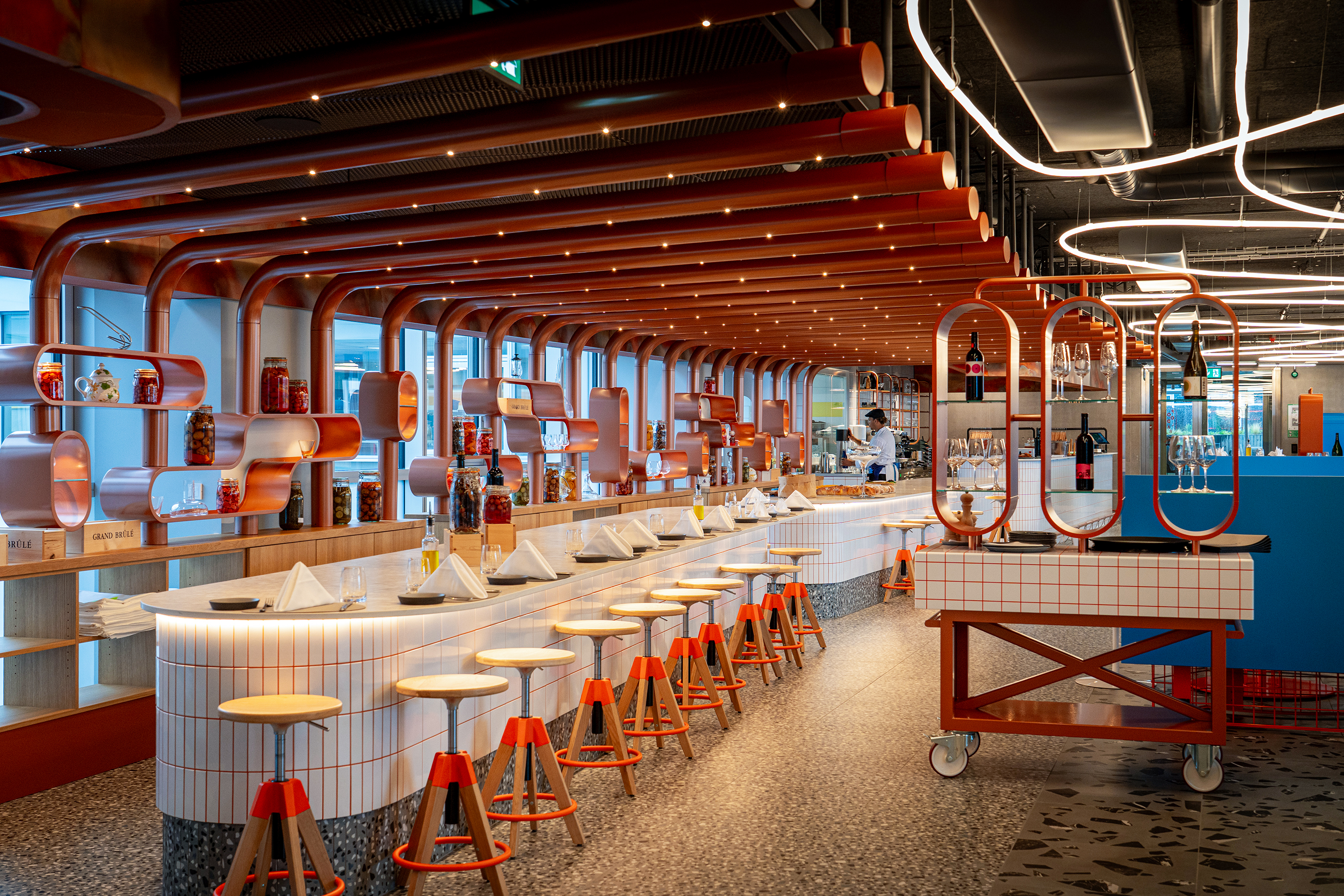 Das À-la-carte-Restaurant mit seinen offenen Küchen. Die Dekoration wurde von einem etablierten Unternehmen aus dem Baugewerbe in Zusammenarbeit mit einem Jugendkollektiv gestaltet.