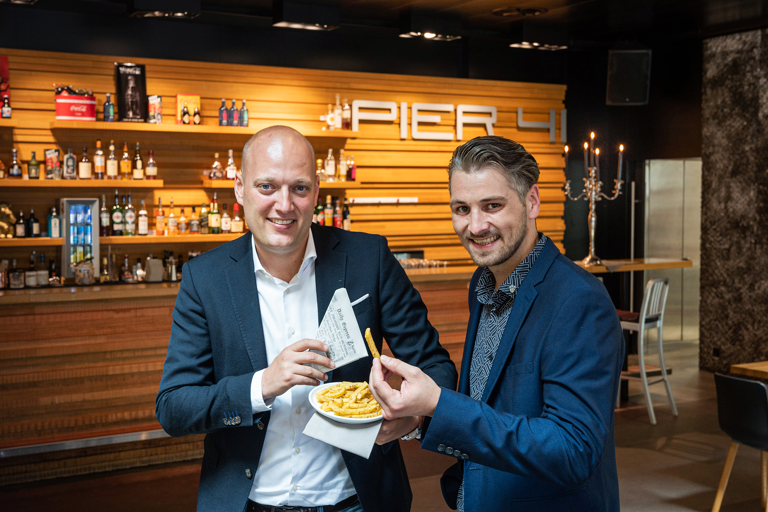 Sie stehen auf Black Pepper Frites und schätzen den zuvorkommenden Service der Kadi AG: Lukas Marcinowski, Leiter Operations bei der EVZ Gastro AG (links), und Marcel Petsch, Betriebsleiter des Pier 41.