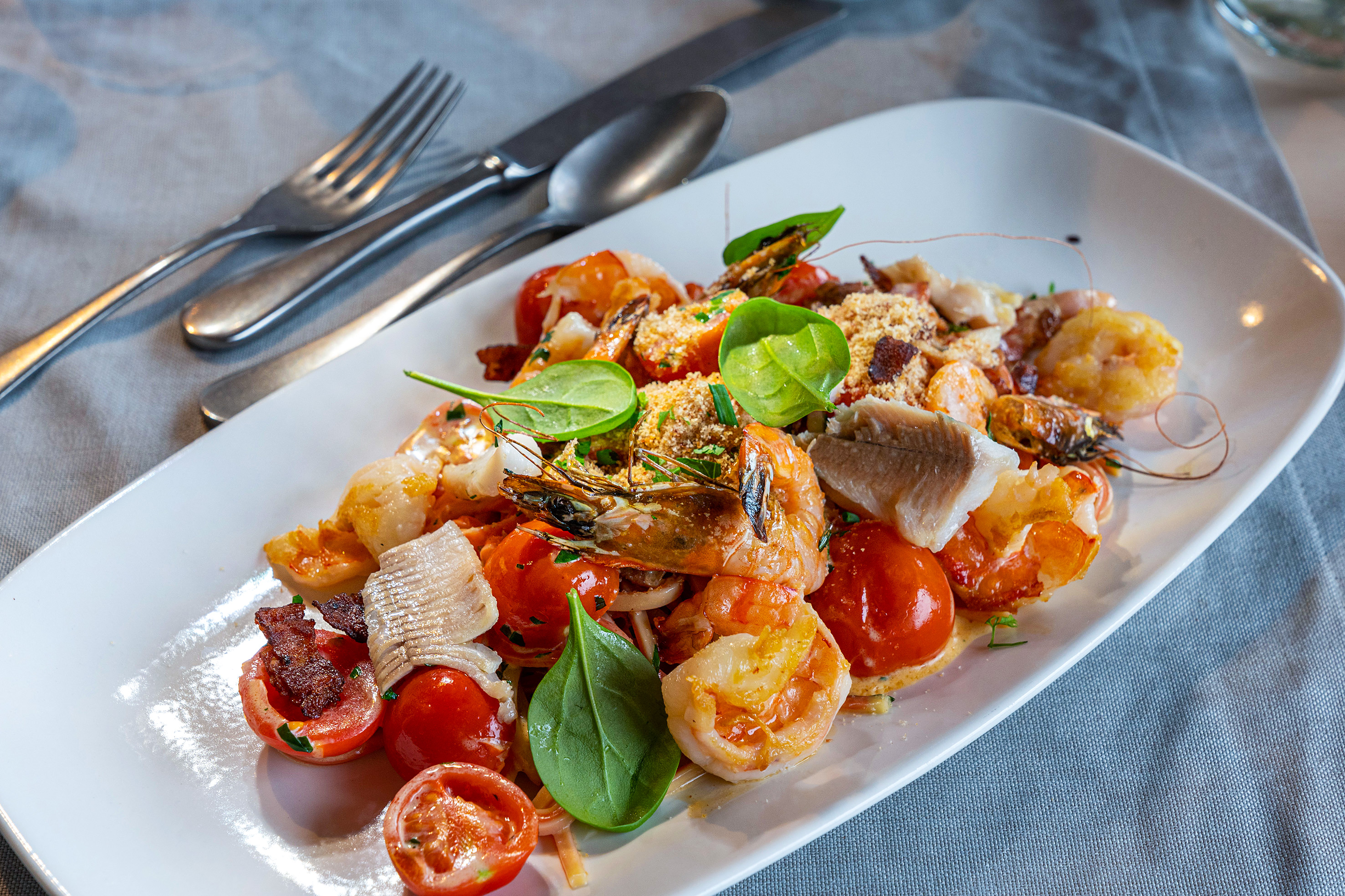 Seemannsgarn, eine der Spezialitäten in der Fischerstube:  Tagliatelle mit gezupften Felchenfilets, Golden Shrimps,  Tomaten, Speck und Semmelbrösel. 