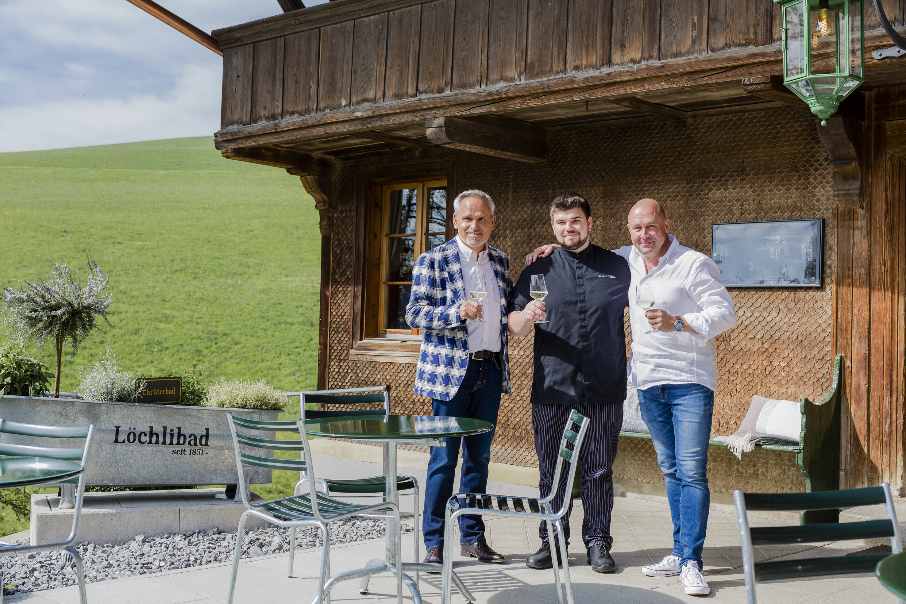 V.l.n.r. Löchlibad-Inhaber Urs Grossen, Küchenchef Michael Schütz und Gastgeber Adrian von Weissenfluh stossen an auf die erfolgreiche Eröffnung.