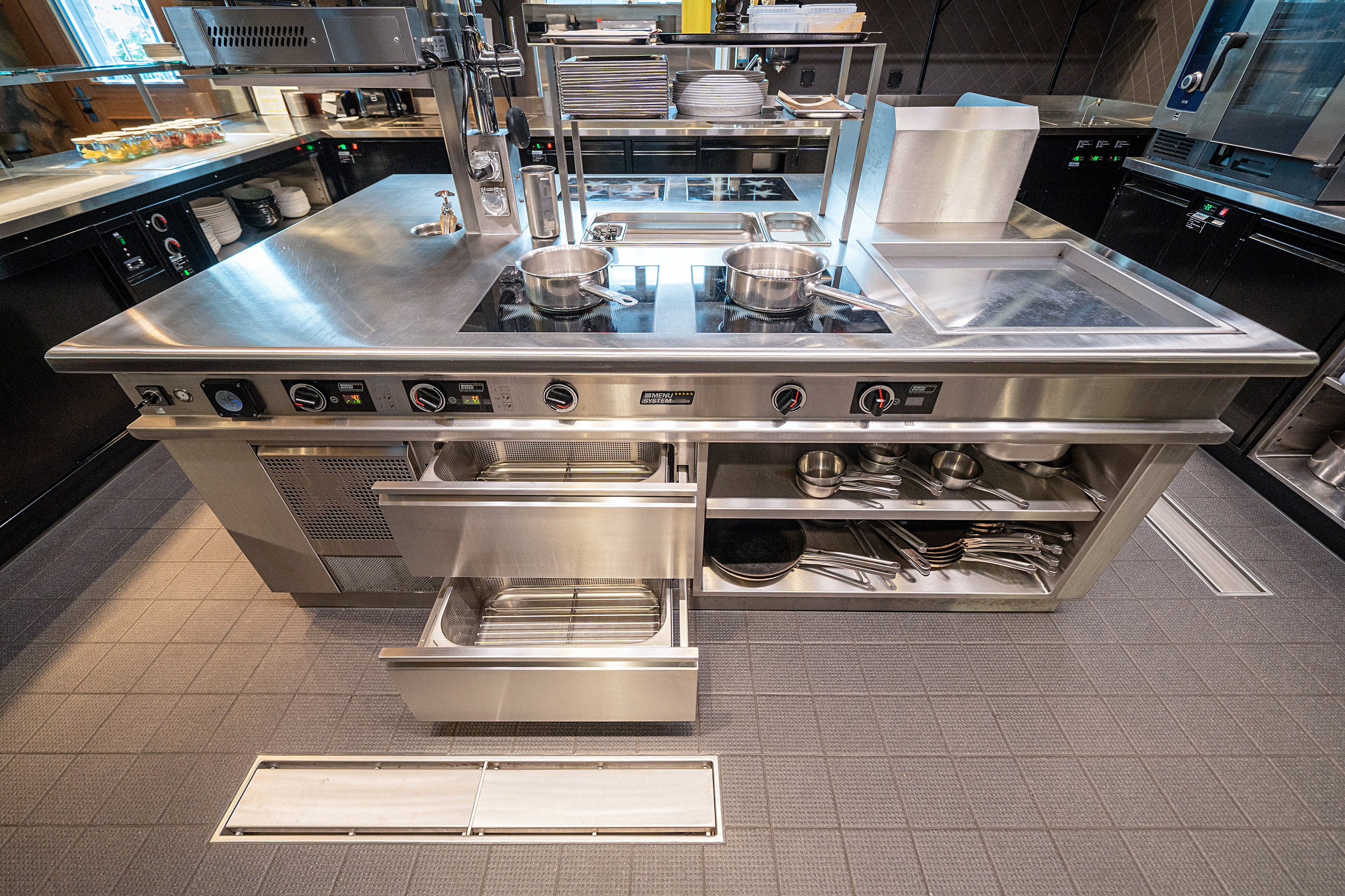 Im Herzen der Show- und Produktionsküche steht ein Premium-Induktionsherd der Menu System AG. Dieser ist mit den nötigen Komponenten ausgestattet, damit Küchenchef Sebastian Rabe und sein Küchenteam den unterschiedlichen Anforderungen von A la Carte- und Seminar- sowie Bankettservice gerecht werden können.